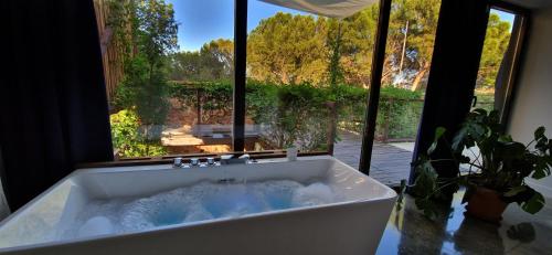 uma banheira num quarto com uma grande janela em Casa Cuartel Centenillo - Alojamientos Rurales en Sierra Morena em El Centenillo