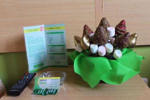 a table with a bowl of candy and a remote control at Hostal Terra 3 - BASE AÉREA in Quito