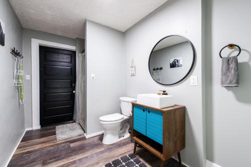 bagno con servizi igienici bianchi e specchio di Suite near downtown Louisville, KY - Suite X a Louisville