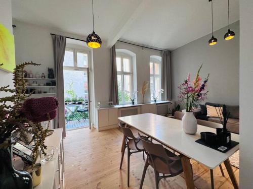 een woonkamer met een grote witte tafel en stoelen bij charming and cozy apartment in Berlijn