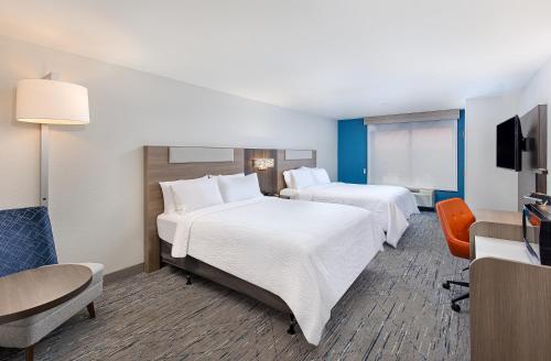 a hotel room with two beds and a flat screen tv at Holiday Inn Express Savannah South I-95 Richmond Hill by IHG in Richmond Hill