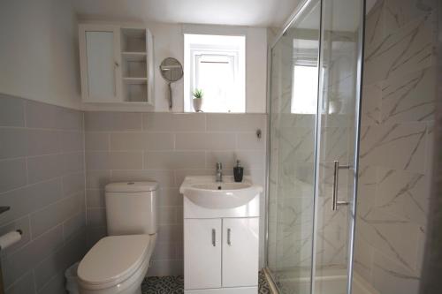 a bathroom with a toilet and a sink and a shower at Modern 3 Bedroom Home in Northampton by HP Accommodation - Free Parking & Super Fast WiFi in Northampton