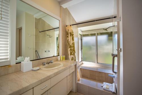 a bathroom with a sink and a mirror and a tub at Kapalua Villas Maui - Select Your Unit in Kahana