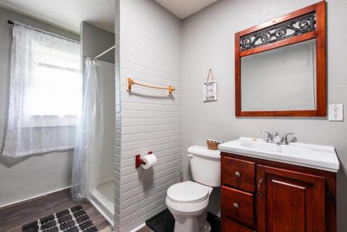 a bathroom with a toilet and a sink and a mirror at Suite near downtown Louisville, KY - Suite XI in Louisville