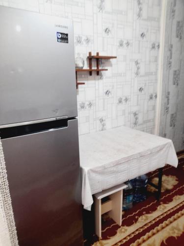 a kitchen with a table and a refrigerator at SAMIR GUEST HOUSE in Ganja