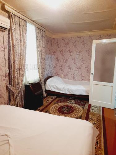 a small room with two beds and a window at SAMIR GUEST HOUSE in Ganja