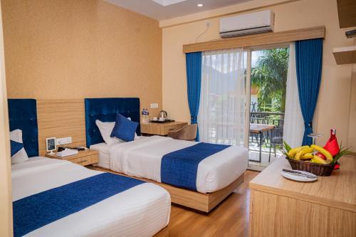 a hotel room with two beds and a balcony at Majestic Lake Front Hotel & Suites in Pokhara