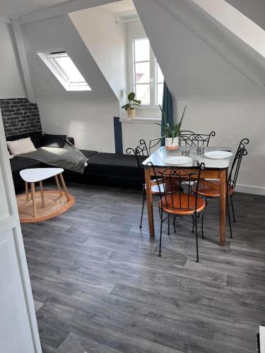 un salon avec une table, des chaises et un canapé dans l'établissement La Cabane du Pêcheur, à Dieppe