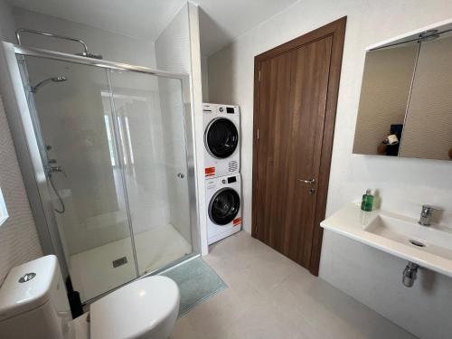 a bathroom with a toilet and a washing machine at Ta Xbiex Sea Front Penthouse in Taʼ Xbiex