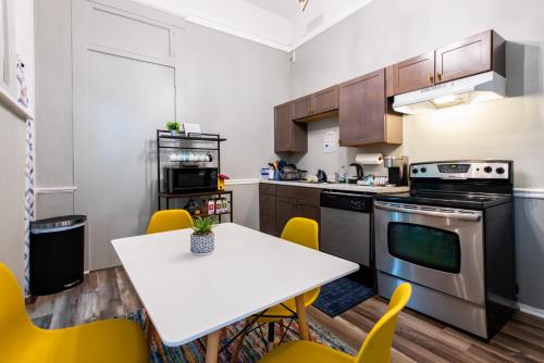 a kitchen with a white table and yellow chairs at Suite near downtown Louisville, KY - Suite VIII in Louisville