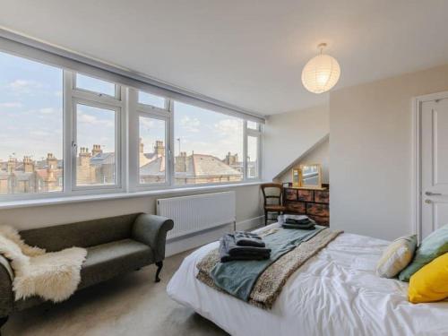 a bedroom with a bed and a couch and windows at Walpole House sleeps 19-24 in Margate