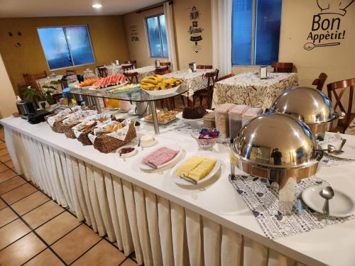 ein Buffet mit Speisen auf einem Tisch in einem Restaurant in der Unterkunft Hotel Graju Itajaí in Itajaí