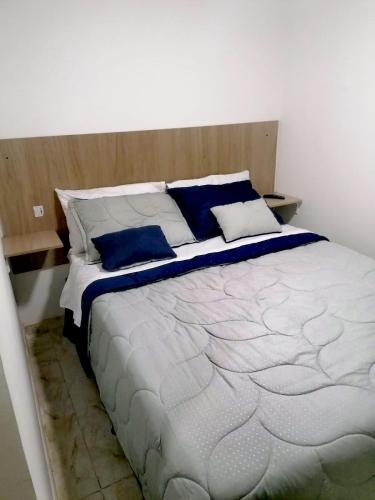 a bedroom with a large bed with blue pillows at Hospedaje 51b in Bogotá
