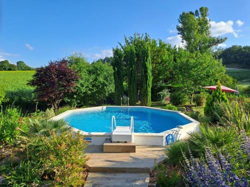 une piscine au milieu d'un jardin dans l'établissement Chambres d'hôtes Le Muguet, à Mandacou