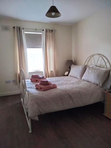 a bedroom with a large bed with towels on it at Community Courtyard Bungalow Apt in Drogheda