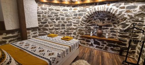 um quarto com uma cama e uma parede de pedra em Lazarov Suites - country style luxury appartements em Veliko Tarnovo