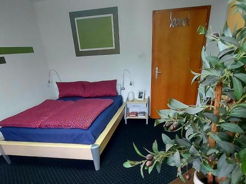 a bedroom with a bed and potted plants in it at Über den Dächern von Furth im Wald in Furth im Wald