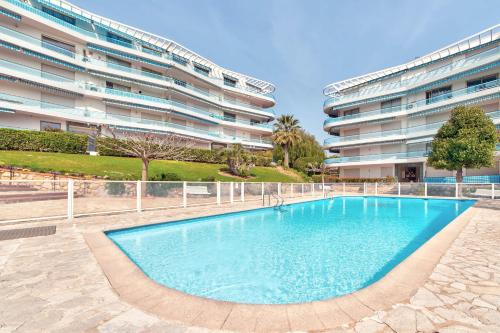 une piscine devant un immeuble dans l'établissement La pinede Apartement equiped with air conditioning and a pool!, à Antibes