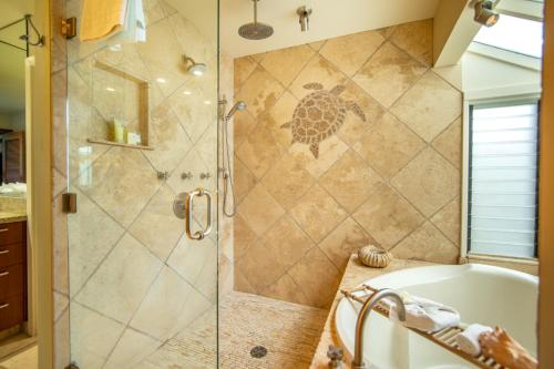 a bathroom with a tub and a shower with a glass door at Kapalua Villas Maui - Select Your Unit in Kahana