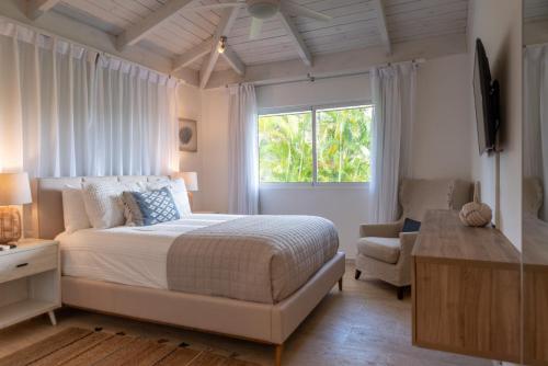 a bedroom with a bed and a window and a chair at Family-Friendly 4-Bedroom Golf Villa with Private Pool, Jacuzzi, and Golf Cart in La Romana