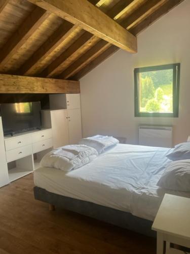 a bedroom with a bed and a television in it at Luxurious new villa in the Alpes with sauna and jacuzzi in Bellevaux