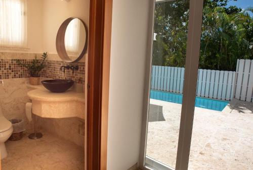 y baño con lavabo y espejo. en Family-Friendly 4-Bedroom Golf Villa with Private Pool, Jacuzzi, and Golf Cart, en La Romana