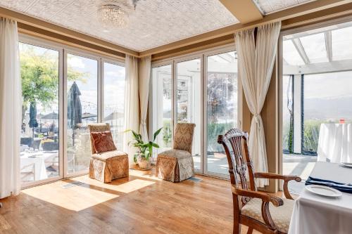 a living room with large windows and a table and chairs at Hotel Eldorado at Eldorado Resort in Kelowna