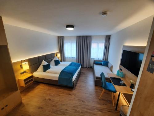 a hotel room with a bed and a couch at Gasthof Krone Ochsenfeld in Ochsenfeld