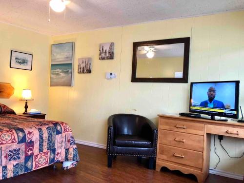 a bedroom with a bed and a desk with a television at Lakelawn B&B and Motel in Yarmouth
