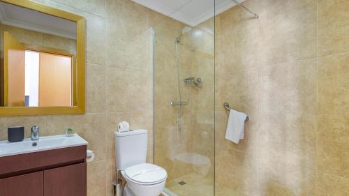 La salle de bains est pourvue d'une douche, de toilettes et d'un lavabo. dans l'établissement Portimão 1BDR Paradise by LovelyStay, à Portimão