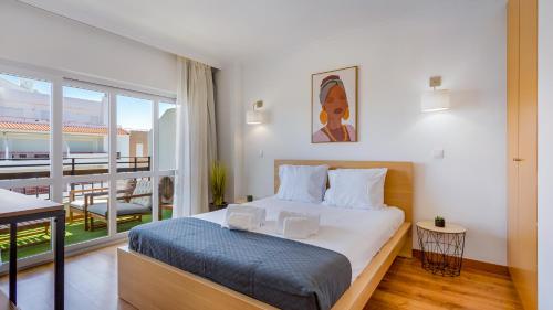 1 dormitorio con 1 cama grande y balcón en Portimão 1BDR Paradise by LovelyStay, en Portimão