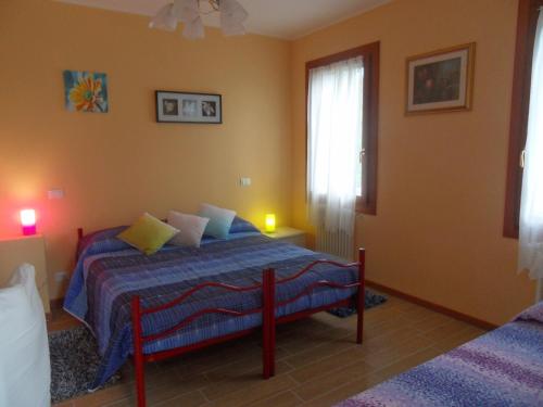 1 dormitorio con 1 cama con manta azul y ventana en B&B Giardino di Ro, en Cazzago di Pianiga