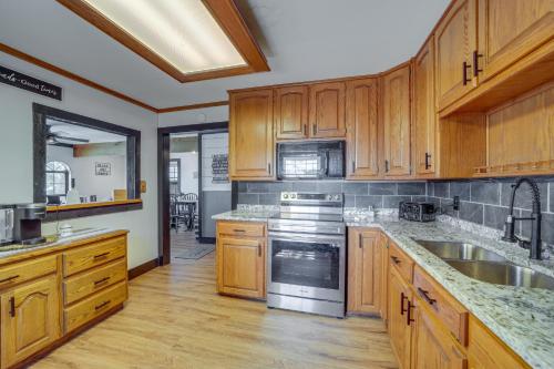 a kitchen with wooden cabinets and stainless steel appliances at Private Boat Slip and Dock Lakefront Grove Retreat! in Grove