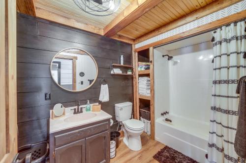 a bathroom with a sink and a toilet and a mirror at Lakefront Grove Retreat Private Boat Slip and Dock! in Grove