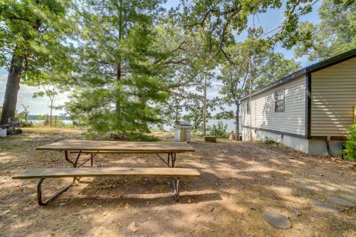 a picnic table in a field next to a building at Private Boat Slip and Dock Lakefront Grove Retreat! in Grove