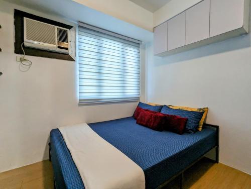 uma cama num quarto com uma janela e uma ventoinha em Premium 1BR at Mplace Music 50 Inch TV Pool pay Extra em Manila