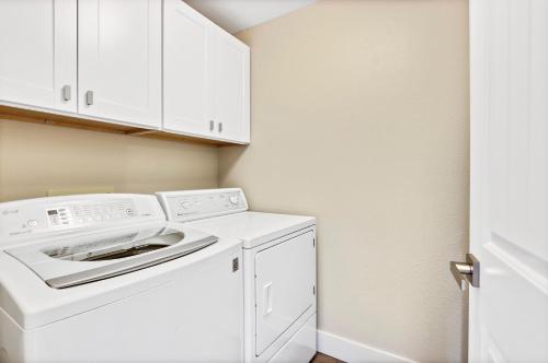uma lavandaria branca com máquina de lavar e secar roupa em Stunning Golf Course Retreat 4BR Home em Eagle