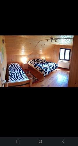 a room with two beds in a wooden cabin at Cabana ciocanu in Şirnea