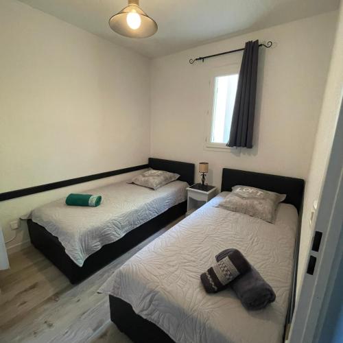 une chambre avec deux lits et une fenêtre dans l'établissement Maison plain pied avec climatisation dans une résidence privée avec piscine, à Saint-Saturnin-lès-Avignon