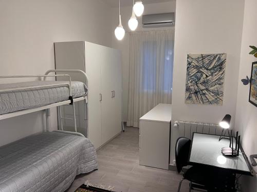 een slaapkamer met 2 stapelbedden, een bureau en een bureau bij La Casa di Dada in Terrasini