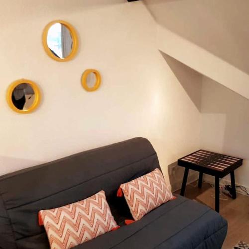 - un salon avec un canapé noir et un miroir dans l'établissement PLEIN CENTRE TRES GRAND STUDIO, à Trouville-sur-Mer