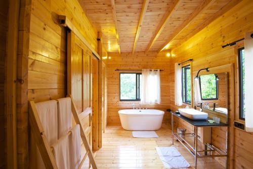a bathroom with a tub in a wooden house at Mountbatten Bungalow- Thema Collection in Kandy
