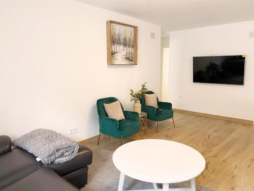 盧戈內斯的住宿－Apartamento bonito，客厅配有沙发、椅子和桌子