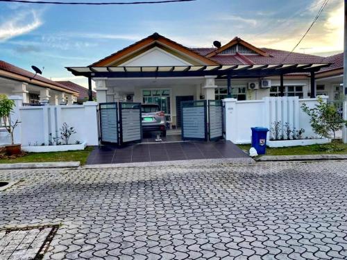 a house with a driveway in front of it at NK HOMESTAY DESARU in Bandar Penawar