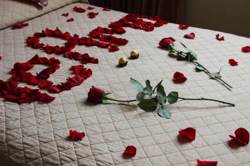 a group of red roses on a white table at Hostal Terra 2 - EL CONDADO in Quito