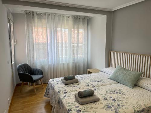 a bedroom with a bed with two pillows on it at León Confort Centro - leonapartamentos in León