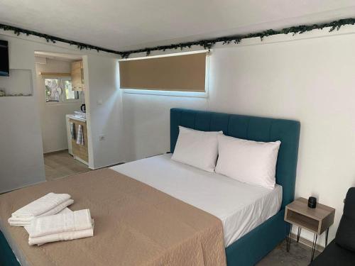 a bedroom with a large bed with a blue headboard at STUDIOS TASOS BI in Chrysi Ammoudia