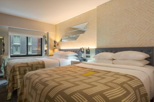 a hotel room with two beds and a window at Pestana CR7 Times Square in New York