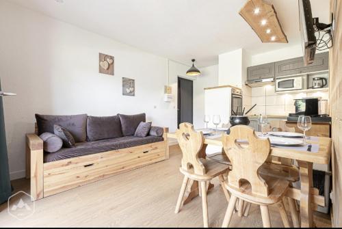 sala de estar con sofá, mesa y sillas en La Norma en Terrasse, en Villarodin-Bourget