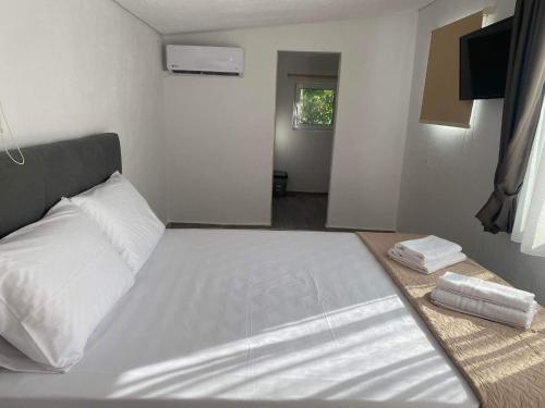 a bedroom with a large bed with two towels on it at STUDIOS TASOS BI in Chrysi Ammoudia